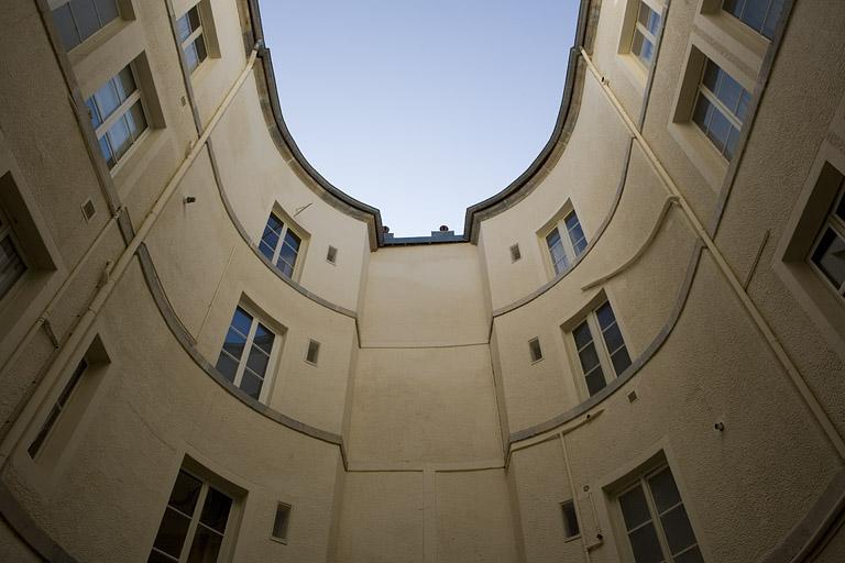 Vue des bâtiments autour de la cour en contre-plongée.