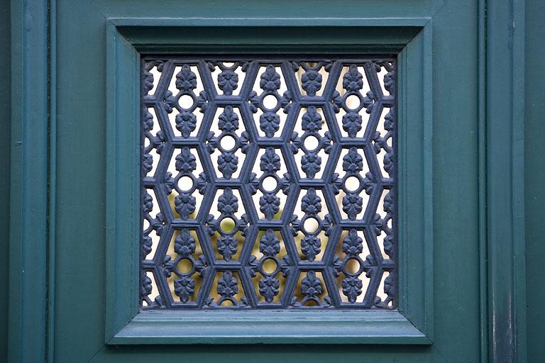 Portail d'entrée : détail du décor en fonte d'un vantail de la porte.