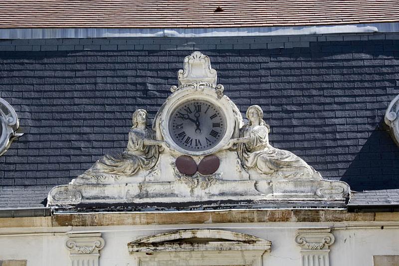 Détail de l'horloge couronnant la partie centrale du logis au fond de la première cour : vue rapprochée.