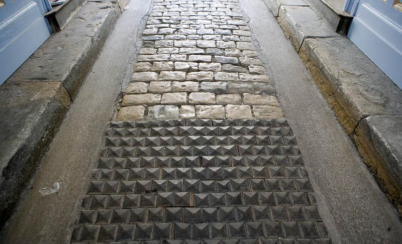 Logis principal : détail des pavés en bois et en pierre du passage cocher.