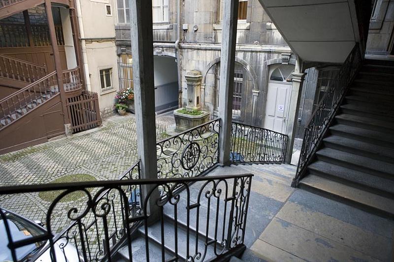 Vue de la rampe en ferronnerie de l'escalier à cage ouverte droit depuis le premier palier.