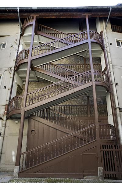 Vue de l'escalier à cage ouverte gauche, de face, depuis la cour.