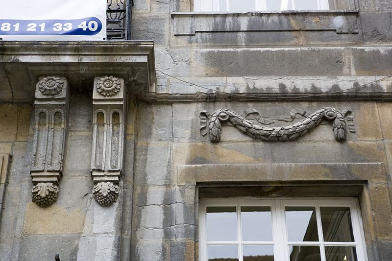 Détail d'une guirlande de feuillage décorant les façades sur cour.