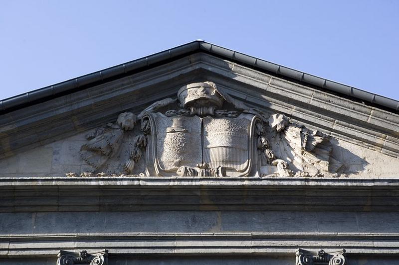 Détail des armoiries bûchées situées dans le fronton couronnant la façade sur rue.