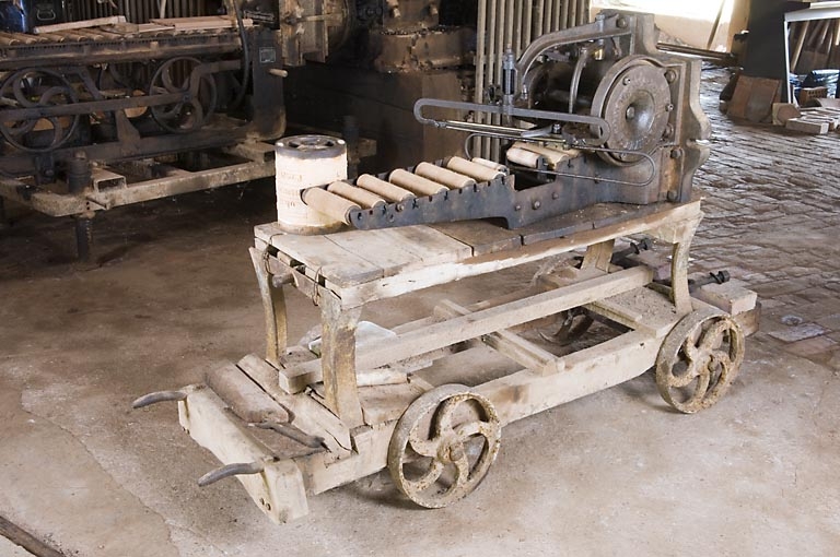 Mouleuse-étireuse pour tuiles sur son chariot découpeur.