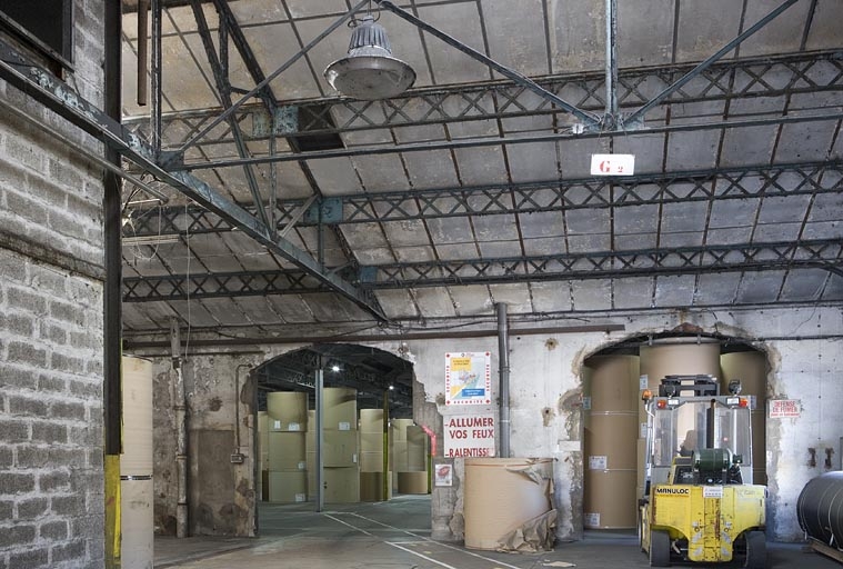 Magasin industriel. Charpente métallique avec poutrelles à treillis.