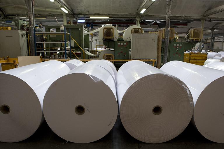 Atelier de façonnage. Découpeuse, et bobines au premier plan.