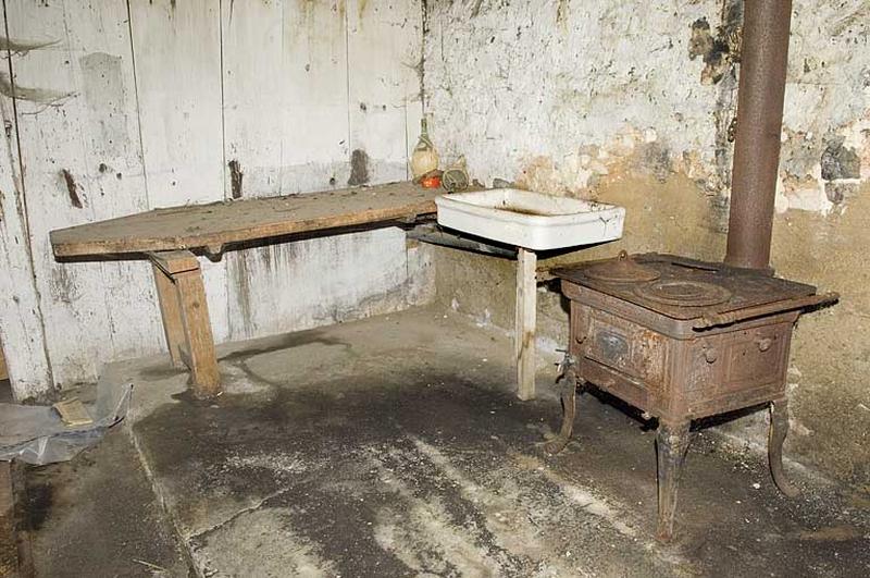 Intérieur de la ferme : la cuisine et le poële en fonte.