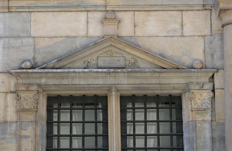 Façade principale : détail du fronton d'une fenêtre du rez-de-chaussée portant la devise des Granvelle.