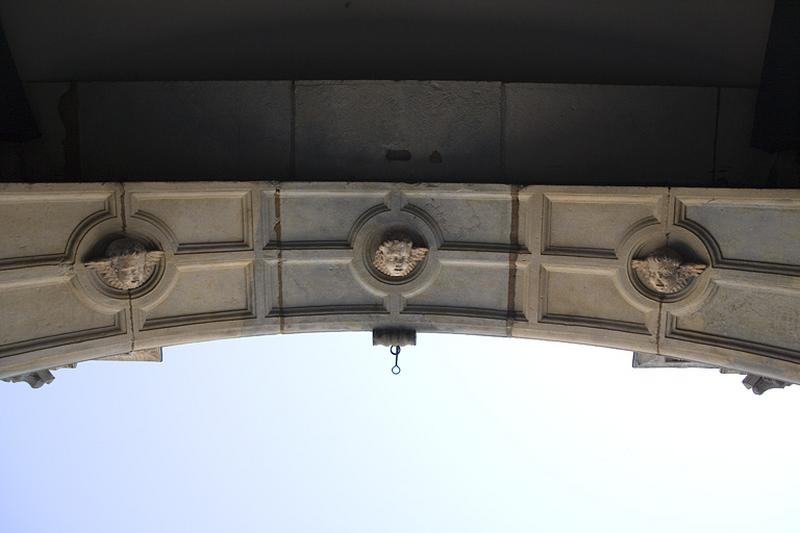 Arc du portail d'entrée : détail de l'intrados décoré de têtes d'anges, depuis le passage cocher.