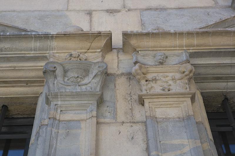 Façade principale : détail de deux chapiteaux encadrant les fenêtres du rez-de-chaussée.