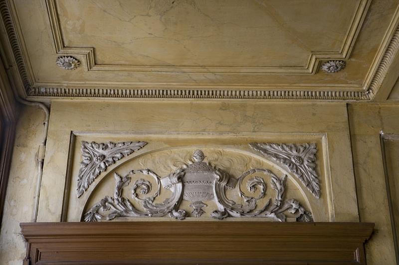 Hôtel en fond de cour, escalier : détail du décor en stuc du dessus de porte, à droite du palier.