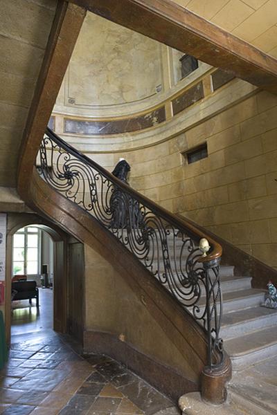 Hôtel en fond de cour, escalier : détail de la première volée avec la rampe en ferronnerie.