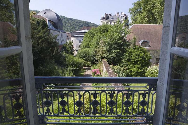 Hôtel en fond de cour : vue du jardin depuis le premier étage, avec le garde-corps de la fenêtre.