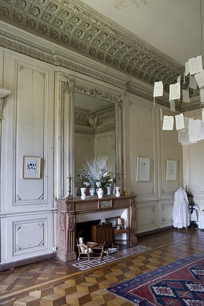 Hôtel en fond de cour, grand salon : vue d'ensemble du mur droit avec la cheminée et sa glace.