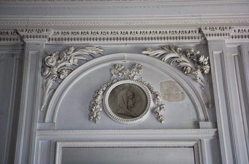 Hôtel en fond de cour, chambre : détail du médaillon peint en grisaille au-dessus de la glace.