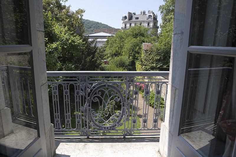 Hôtel en fond de cour : détail de la grille du balcon donnant sur le jardin, depuis l'intérieur.