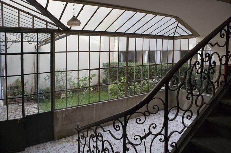 Vue intérieure de la verrière protégeant le rez-de-chaussée de la cage d'escalier.