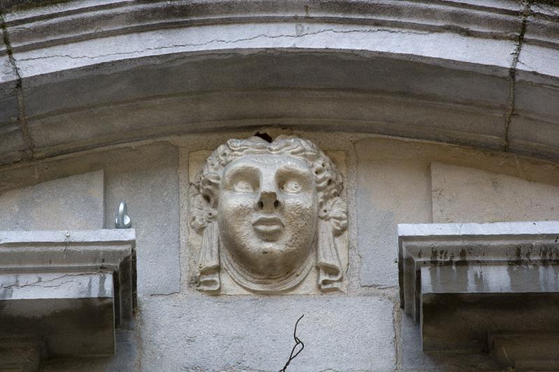 Façade antérieure du logis principal : détail d'une tête sculptée, fronton d'une fenêtre du premier étage.