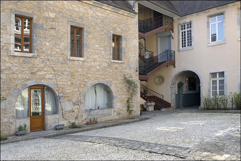Vue d'ensemble du bâtiment des cuisines et de l'escalier à cage ouverte depuis le fond de la cour.