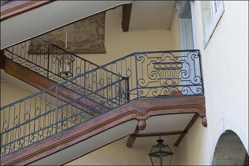 Détail de la rampe en fer forgé de l'escalier à cage ouverte.