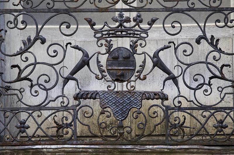 Façade antérieure en fond de cour : détail des armoiries, balcon du premier étage.