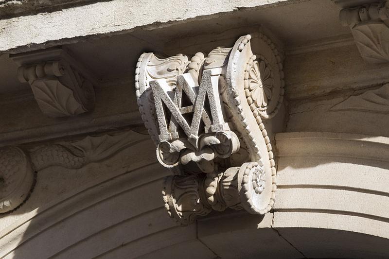 Portail d'entrée : détail du monogramme sur la clé de l'arc.