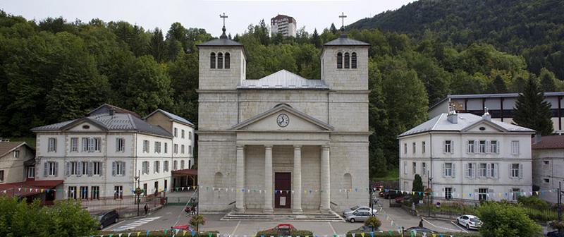 Vue d'ensemble de la place et des bâtiments côté est : école, église et presbytère.