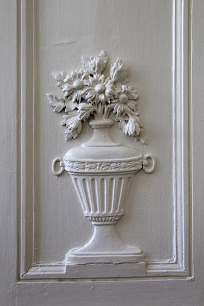 Intérieur, chambre à gauche du salon : lambris, détail d'un pot à fleurs.