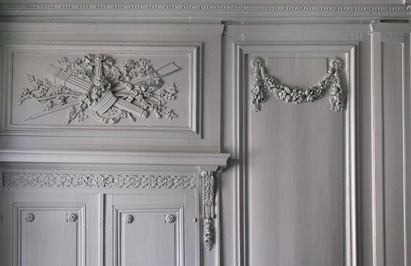 Intérieur, salon : détail du décor d'un dessus de porte et de la partie supérieure d'un lambris.