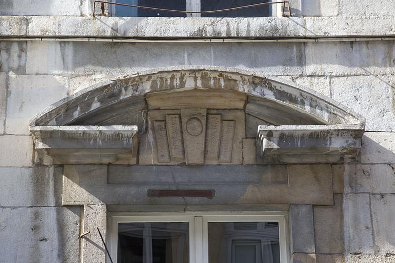 Façade antérieure, partie droite, rez-de-chaussée : détail du fronton de la deuxième fenêtre à partir de la droite.