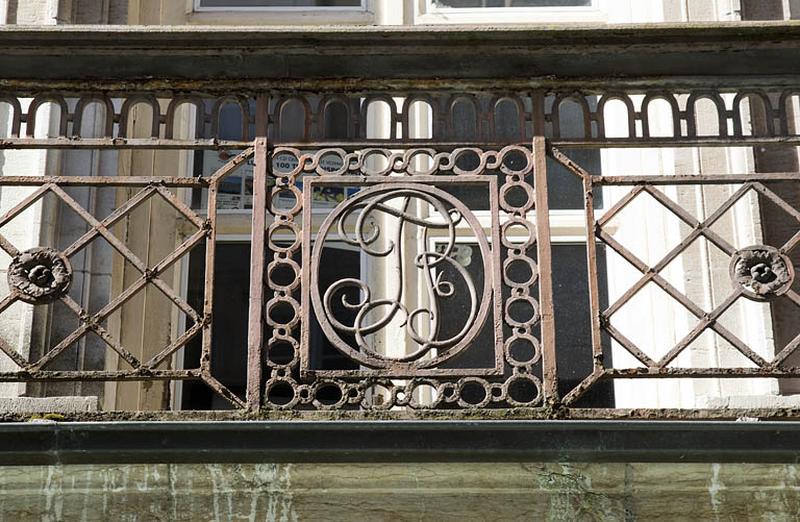 Logis principal, façade sur rue : détail du monogramme du balcon en ferronnerie.