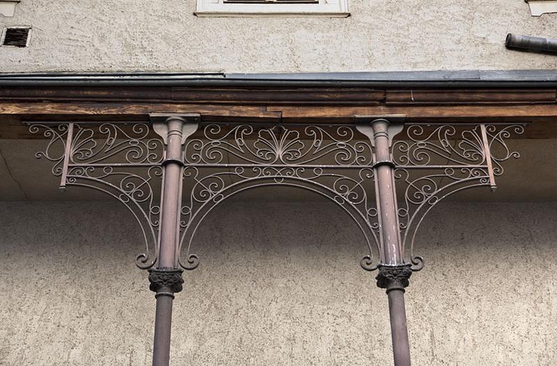 Escalier à cage ouverte sur cour : détail des arcs et des piliers en métal soutenant la galerie, partie centrale.