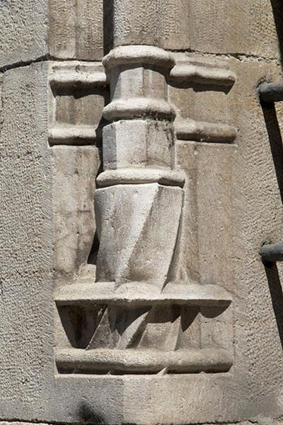 Façade antérieure, fenêtre au-dessus de l'entrée de cave : détail de la base prismatique gauche, vue rapprochée.