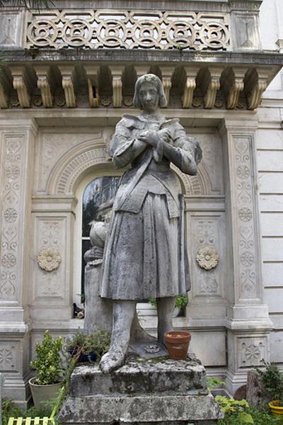 Détail d'une statue de Jeanne d'Arc devant la façade d'angle.