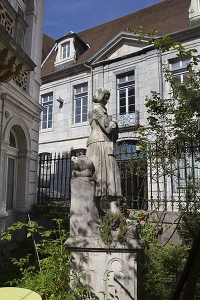 Statue de Jeanne d'Arc devant la façade d'angle : de profil.