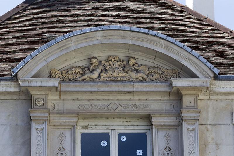 Façade d'angle, deuxième étage, baie centrale : détail du décor du fronton.