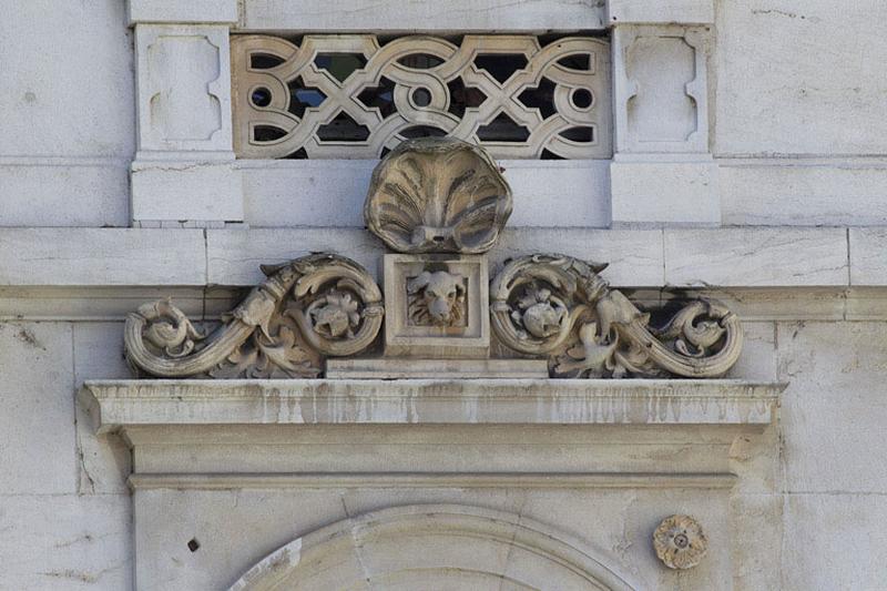 Façade d'angle, premier étage : détail du décor sur l'entablement d'une fenêtre.