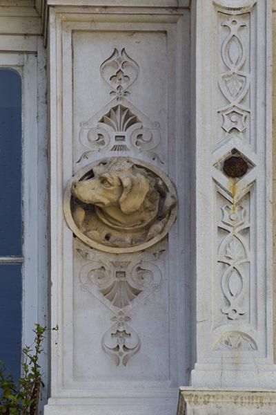 Façade d'angle, deuxième étage, baie centrale, détail du décor droit : tête de chien.