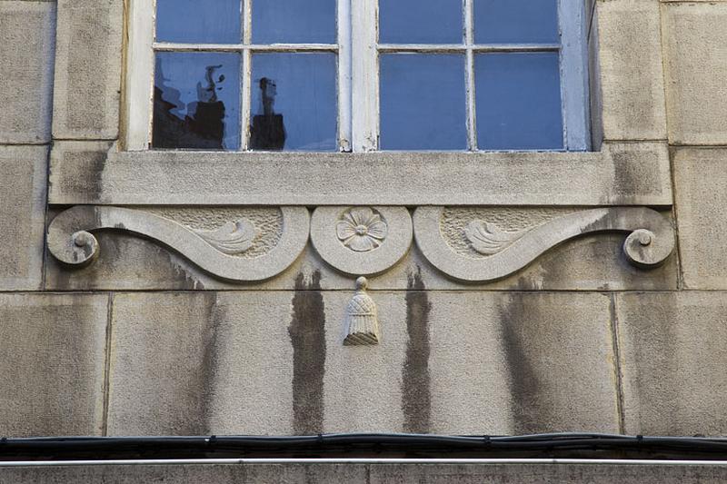 Logis principal, façade antérieure : détail d'un décor situé sous une fenêtre.