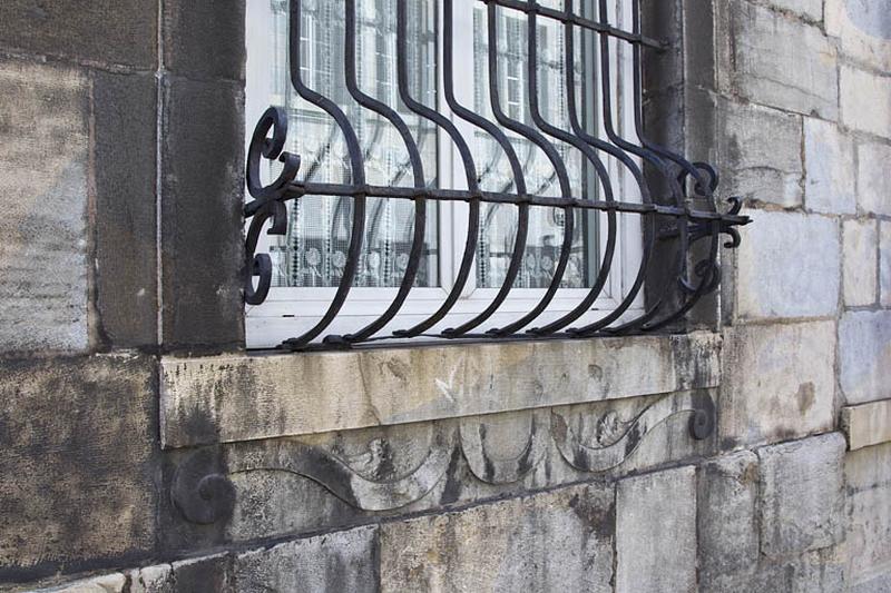 Logis principal, façade antérieure, rez-de-chaussée : détail de la partie inférieure d'une grille de fenêtre.