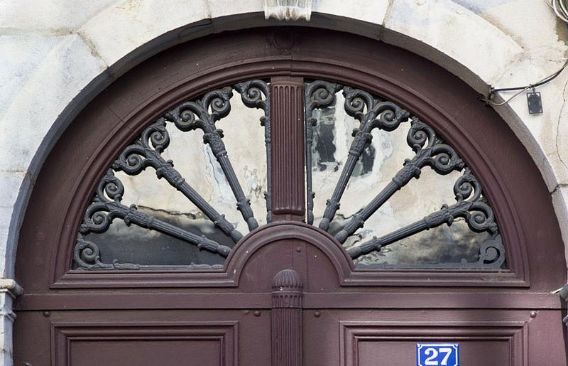 Portail d'entrée : détail du tympan en menuiserie de la porte.