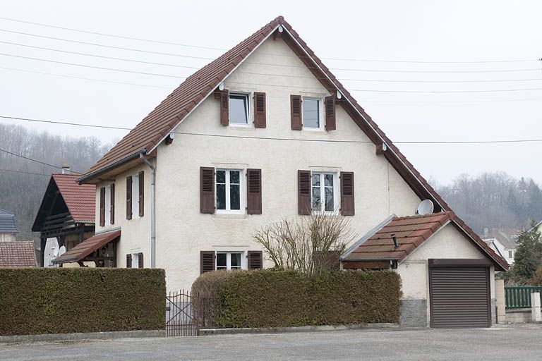 Pignon d'une maison individuelle donnant sur la place publique.
