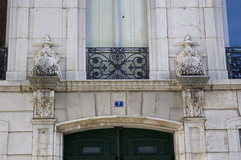 Façade antérieure : détail des décors cantonnant la porte d'entrée.