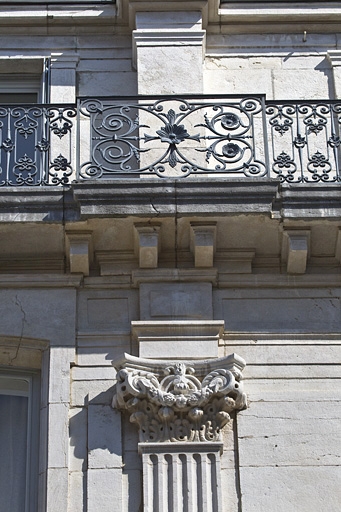 Façade antérieure : détail d'un chapiteau corinthien et du garde-corps de l'étage de surélévation.