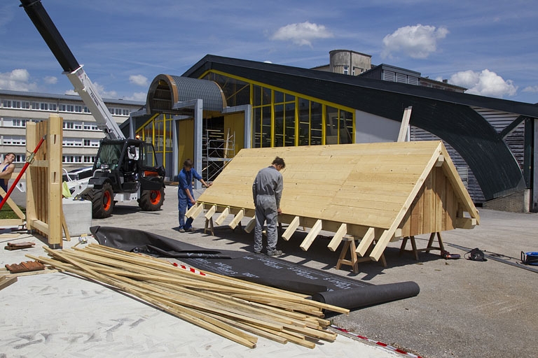 Atelier des métiers du bois et aire de montage : élèves réalisant une toiture.