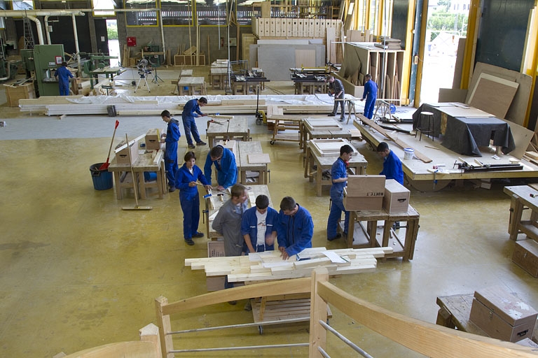 Atelier des métiers du bois : vue plongeante sur les élèves à l'établi.