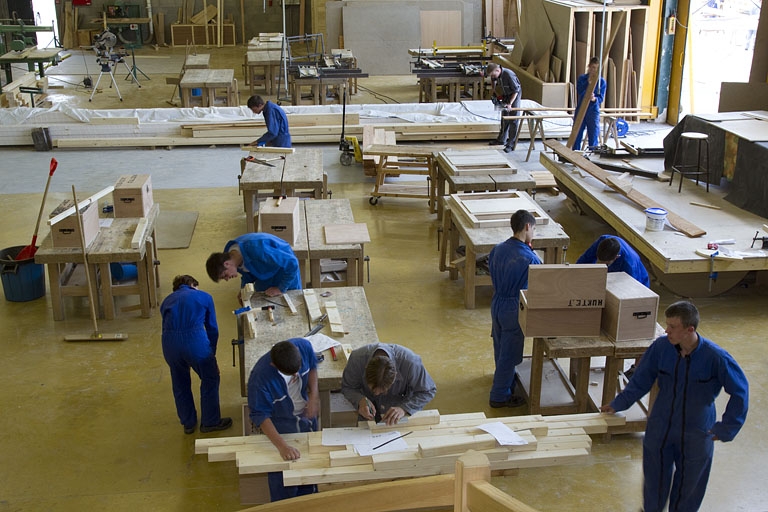 Atelier des métiers du bois : vue plongeante sur les élèves à l'établi.