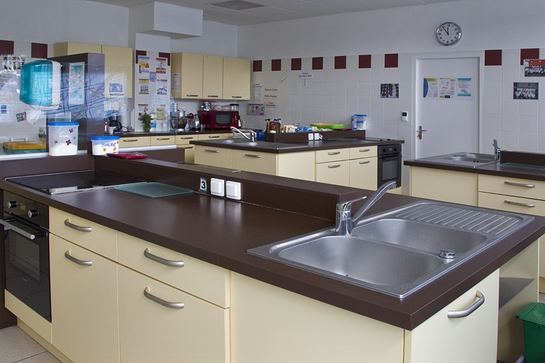 Bâtiment de l'hôtellerie (1er étage) : cuisine pédagogique de la formation sanitaire et sociale. La salle est équipée de différents modèles de cuisinière.