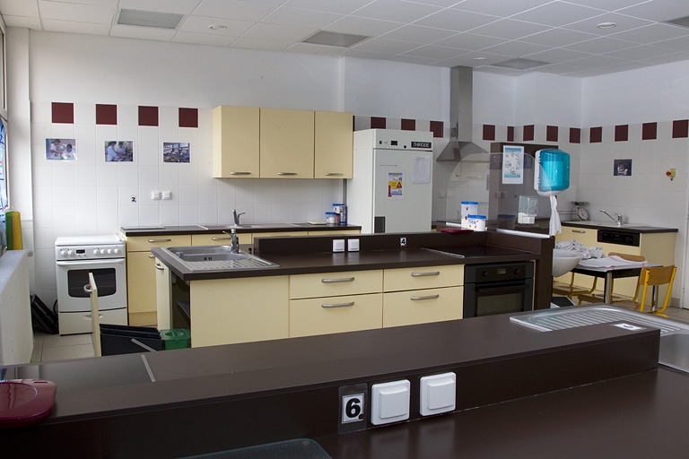 Bâtiment de l'hôtellerie (1er étage) : cuisine pédagogique de la formation sanitaire et sociale. La salle est équipée de différents modèles de cuisinière.